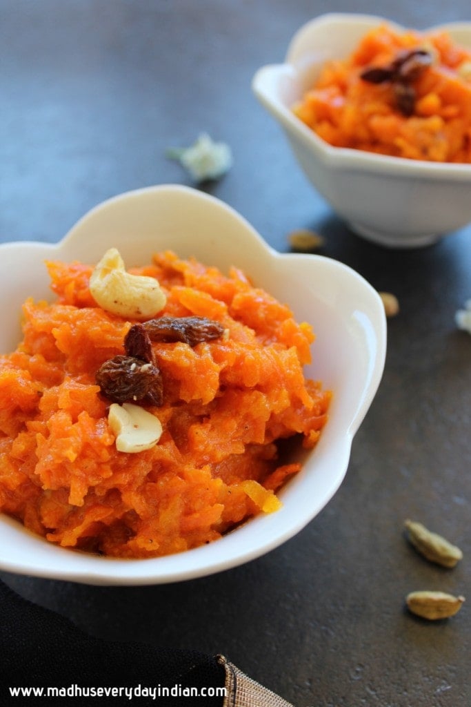 carrot halwa served in white bowl and topped with nuts