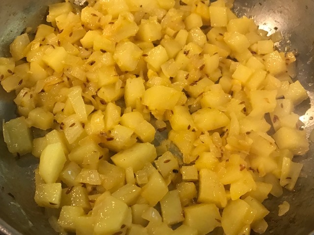 adding potato to sauteed onion