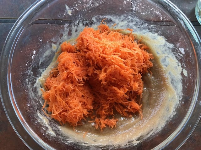 add grated carrots to the beaten eggs and flour
