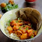 potato loquat curry serve with rice and roti in a bowl