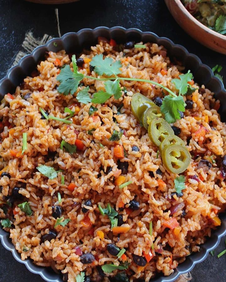 mexican rice served in a grey large bowl and garnished with jalapeno and coriander leaves