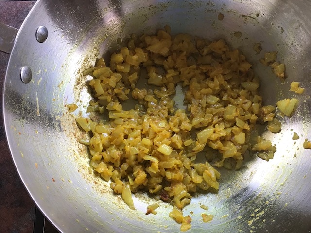 sauteed onion, turmeric in a wok