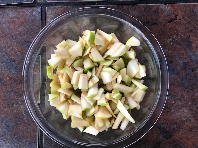 thinly sliced green apple in a large glass bowl