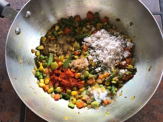 red chili powder and coriander powder , coconut added to the sauteed frozen veggies