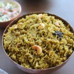 palak biryani served in a bowl and in the background is raita