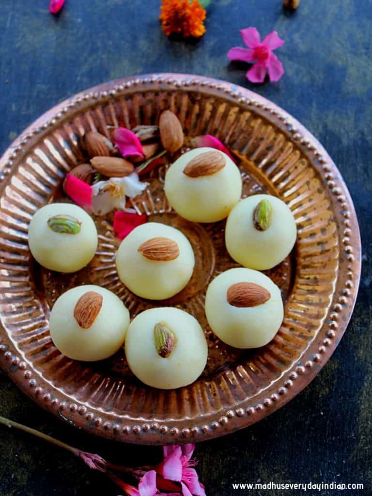 malai peda swerved in a plate with almonds and few flowers for garnish