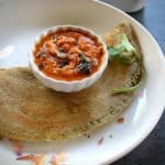 moong dal dosa folded served with ginger chutney in a white plate