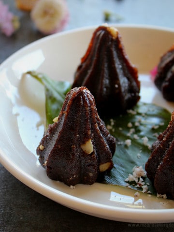ragi modak arranged in a white plate and garnished with coconut