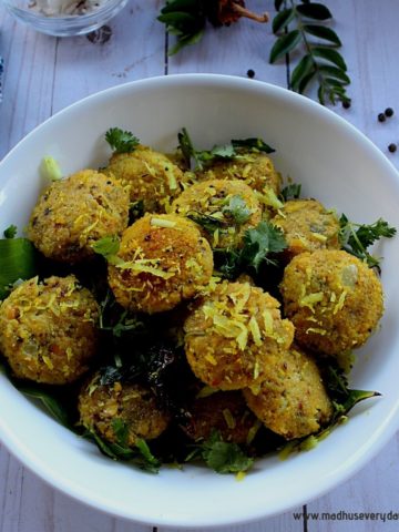 steamed chana dal vada served in a white bowl with a tempering of mustard and coconut