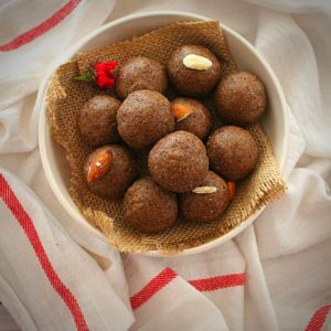 flax seed ladoo served in a white bowl garnished with almonds