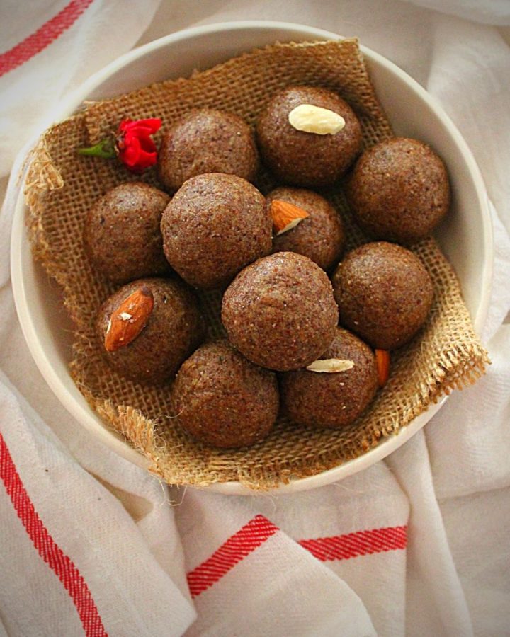 flax seed ladoo served in a white bowl garnished with almonds