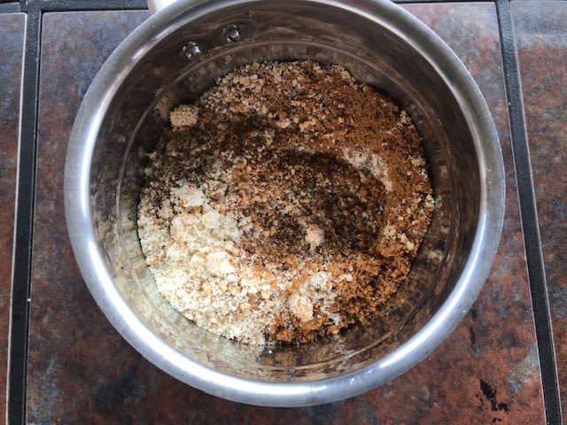 powdered nuts and flax seeds added to the mixer jar with cardamom and jaggery