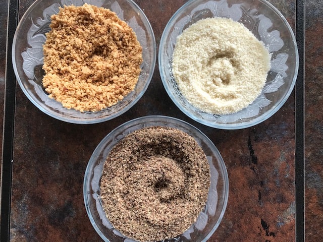 powdered flax seeds, almonds and peanuts in three glass bowls.