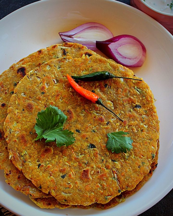 oats paratha served with pcikle, raita and onion, green chili