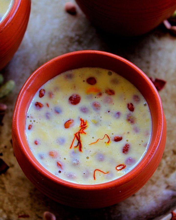 badam milk served in clay pots topped with saffron and nuts