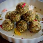 paan coconut nuts ladoo served in a white bowl garnished with rose petals