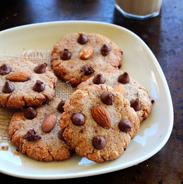 5 almond flour cookies served in a plate with apples and coffee