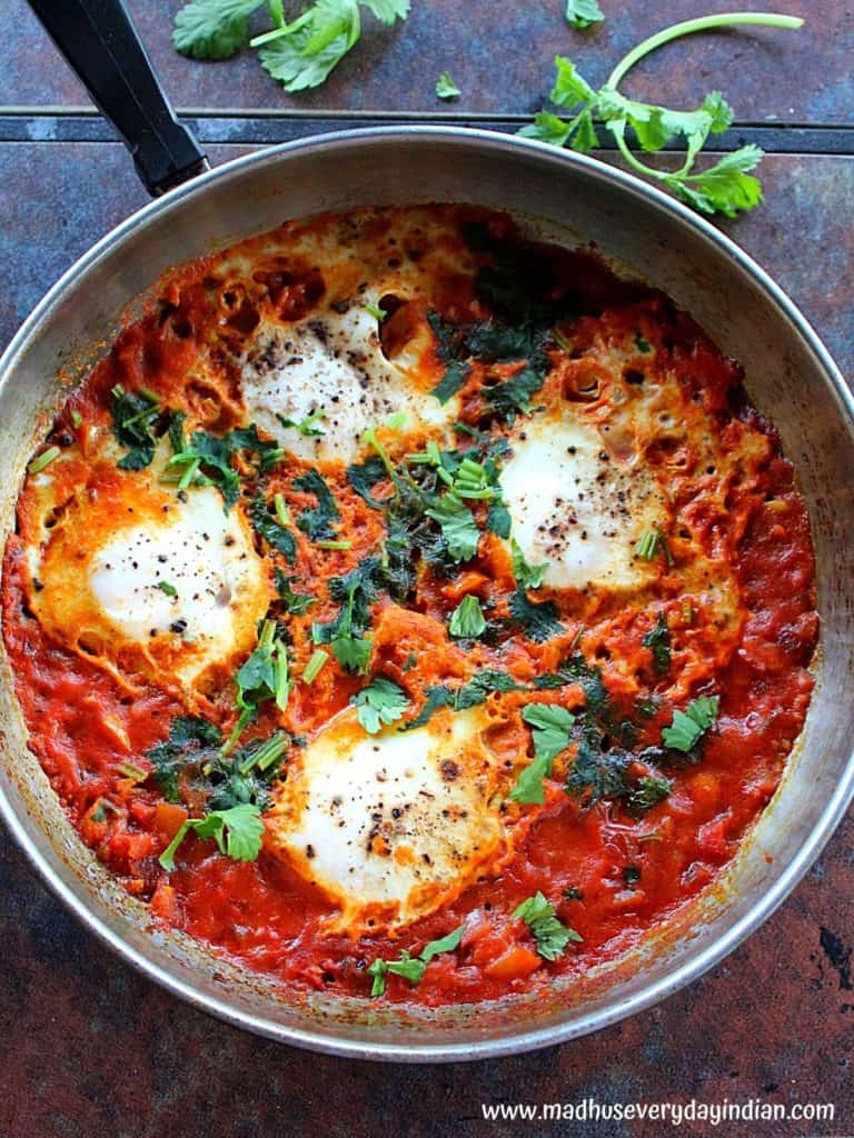 Indian style Shakshuka served in a steel saute pan garnished with cilantro