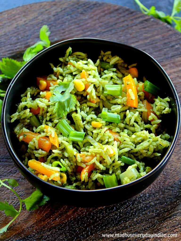 indian style spinach fried rice served in a black bowl garnished with coriander leaves