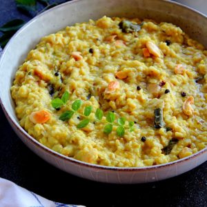 oats ven pongal served in a large plate garnished with curry leaves