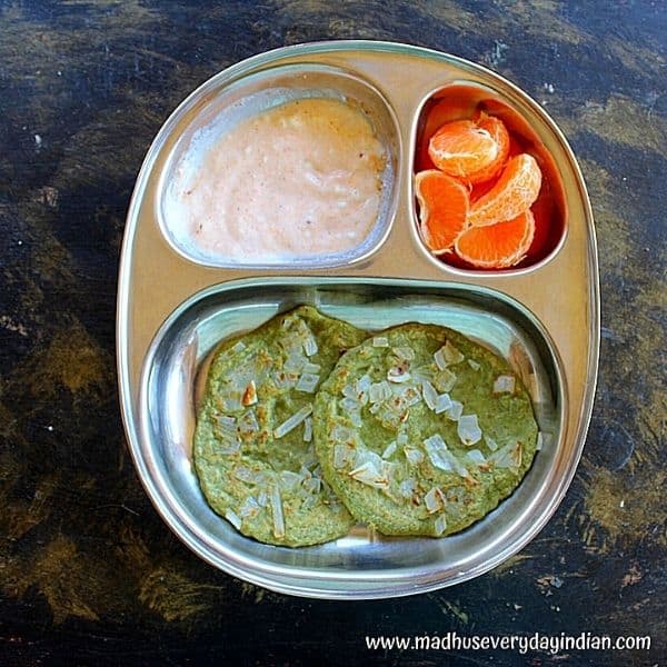 2 mini green moong dal dosa served with yogurt and podi and orange