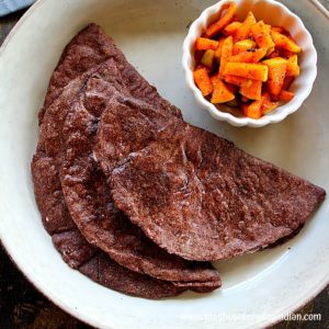 4 ragi roti served with green apple pickle in a large plate
