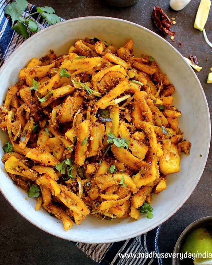 jackfruit fry served in a large white plate with lemon and coriander leaves