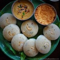 jowar idli served in a green plate with peanut chutney and chutney podi