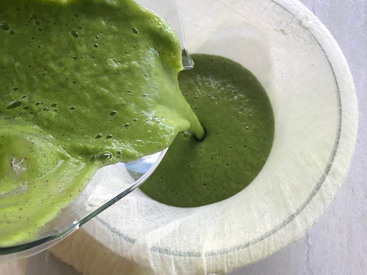 green juice is being poured in to the cheese cloth