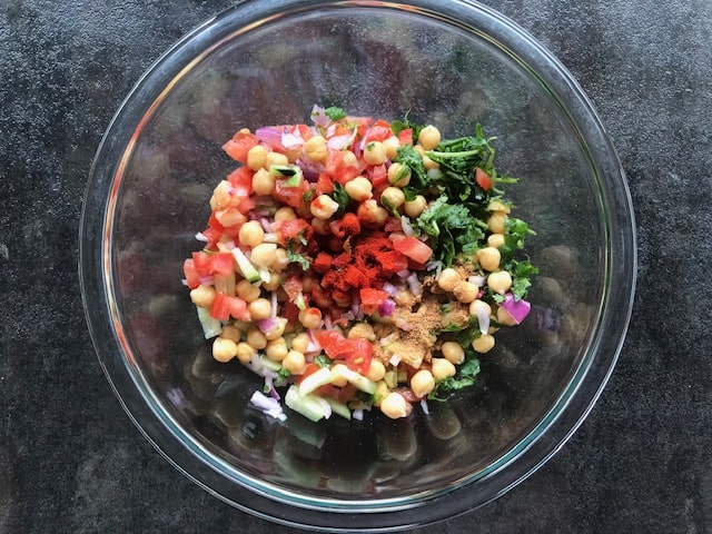 chickpeas, veggies, red chili powder and salt added to a glass bowl