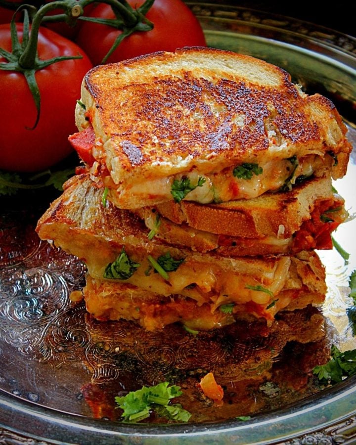 stacked tomato chutney grilled cheese in a metal plate