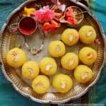 rava kesari ladoo served in a silver plate garnished with flowers