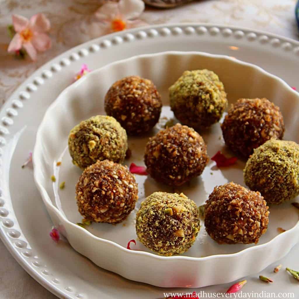 9 coconut nuts ladoo are arranged in a plate with rose petals