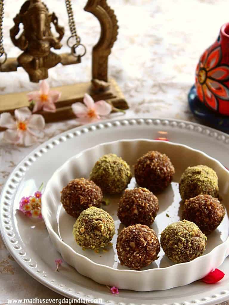 9 coconut nuts ladoo with jaggery are placed in a plate with rose petals