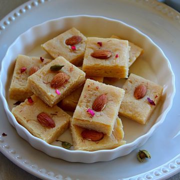 ricotta cheese and badam burfi served in a white plate