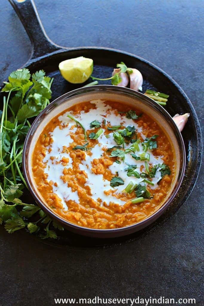 vegan red lentil curry served in a brown bowl