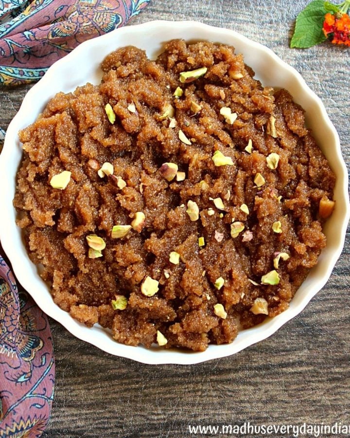 sooji halwa with jaggery garnished with nuts and served in a white plate