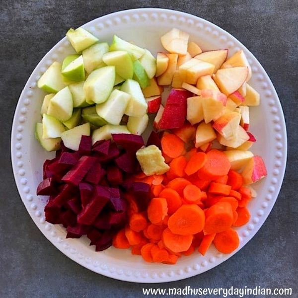 chopped apple, carrot, beets and ginger placed in a large white plate
