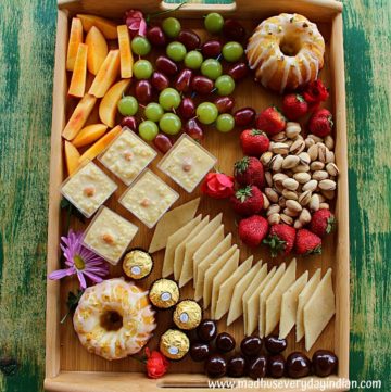 assorted desserts, nuts and fruits arranged in a board