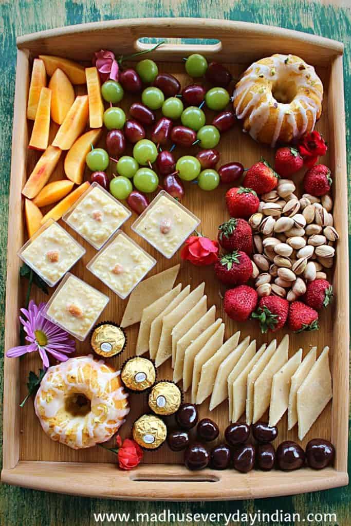 assorted desserts, nuts and fruits arranged in a  board