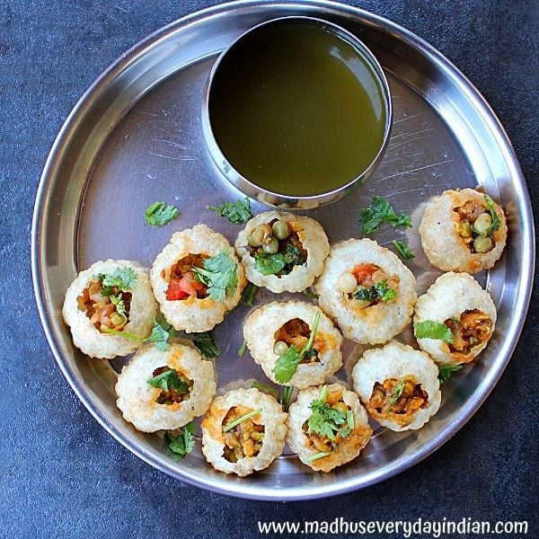 pani puri stuffed and served with pani in a steel plate