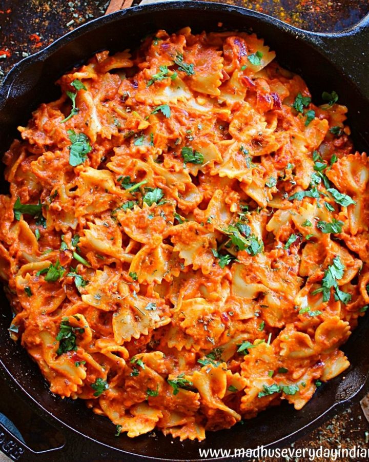 tikka masala pasta served in a cast iron skillet sprinkled with herbs