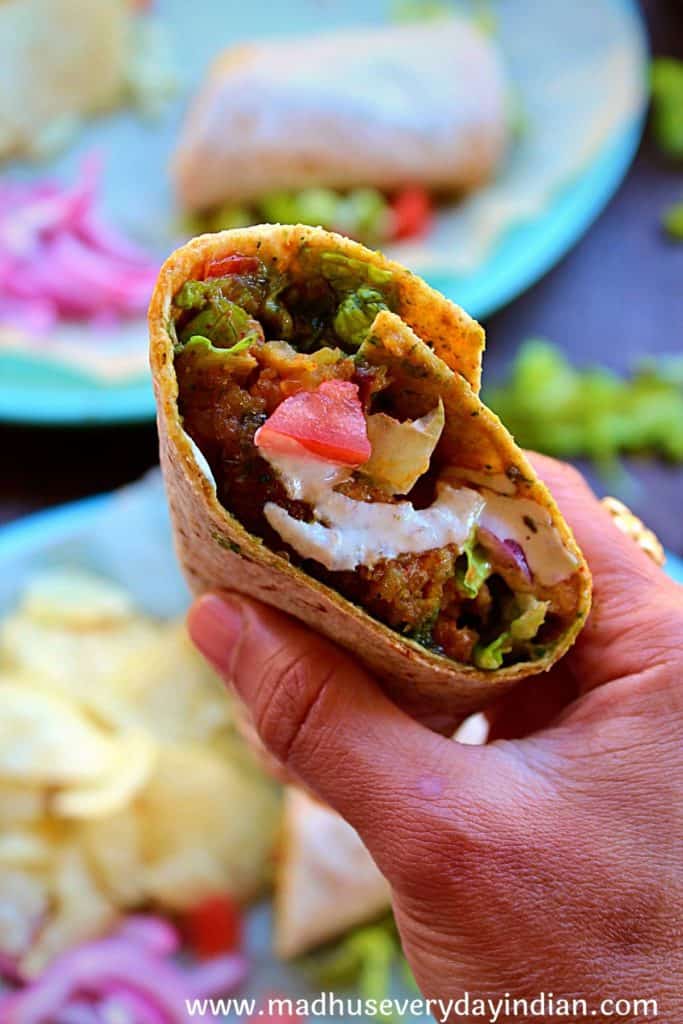 indian style burger wrap held in the hand
