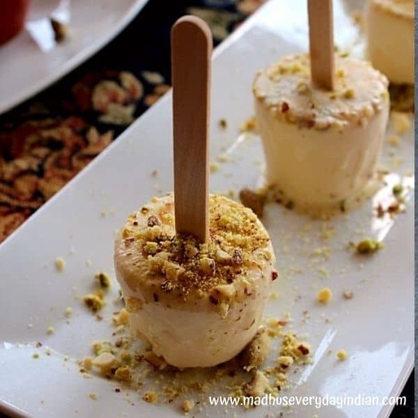 kulfi erved in a stick topped with chopped pistachio