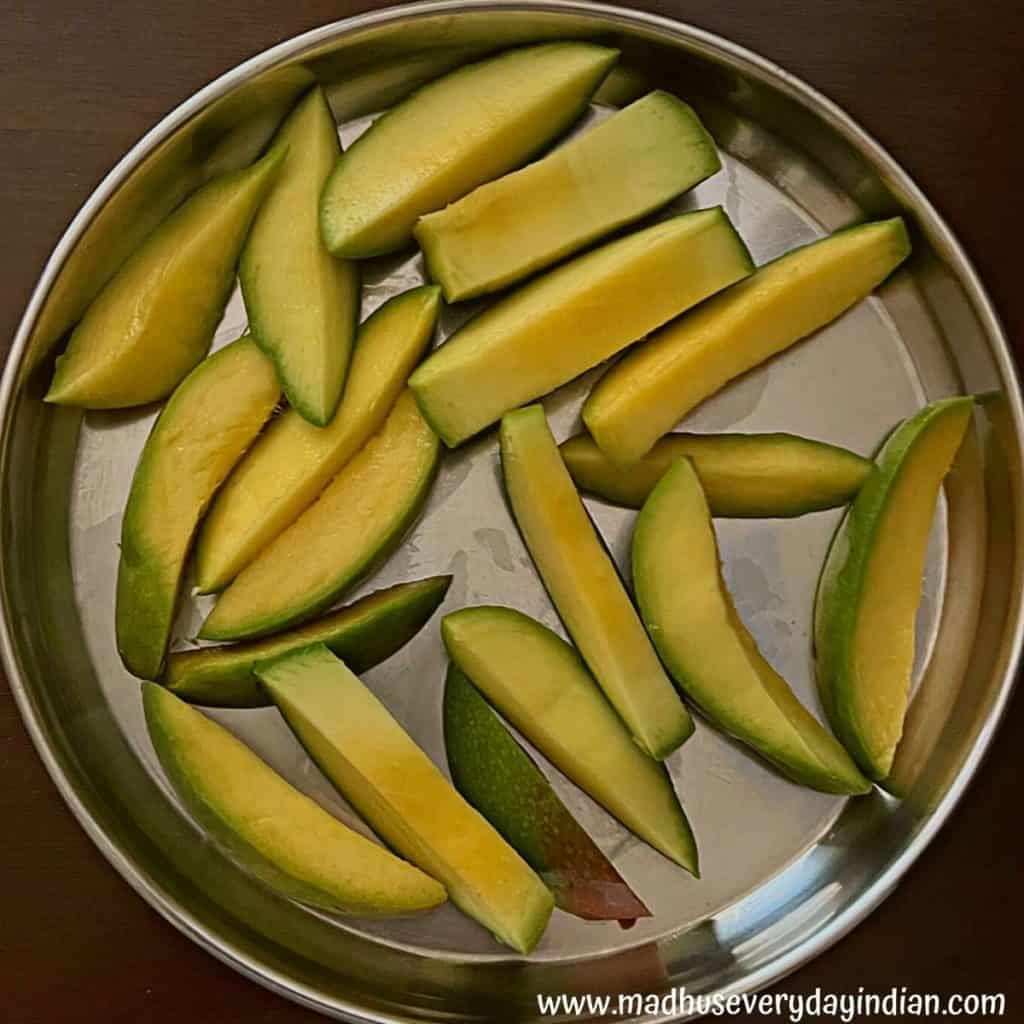 slices of mango pieces served in a steel plate