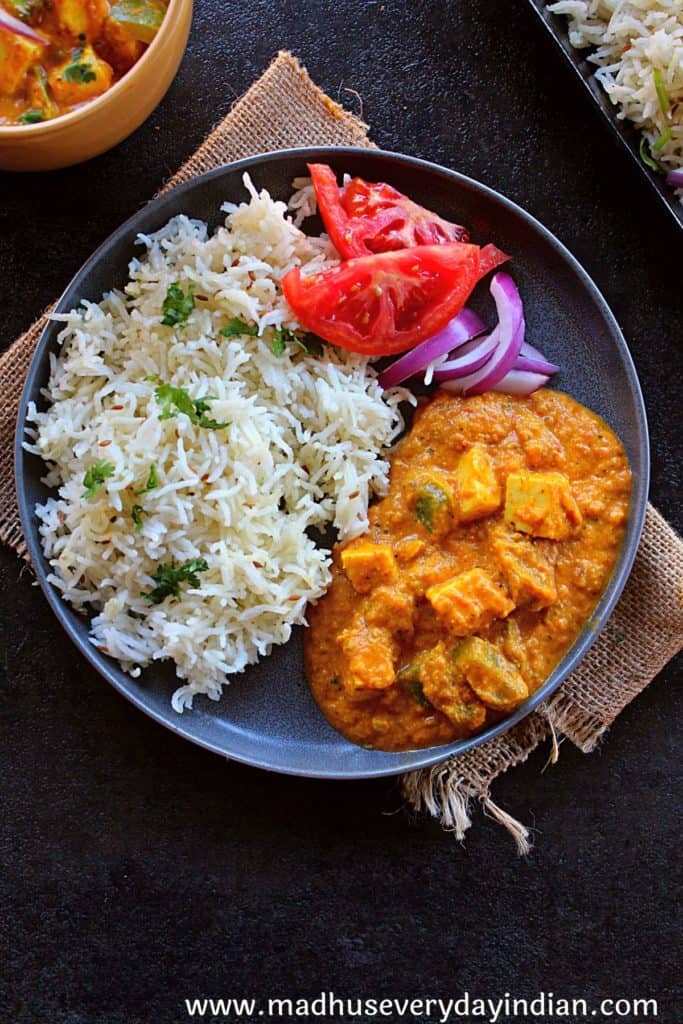 paneer curry served with rice, tomato and onion