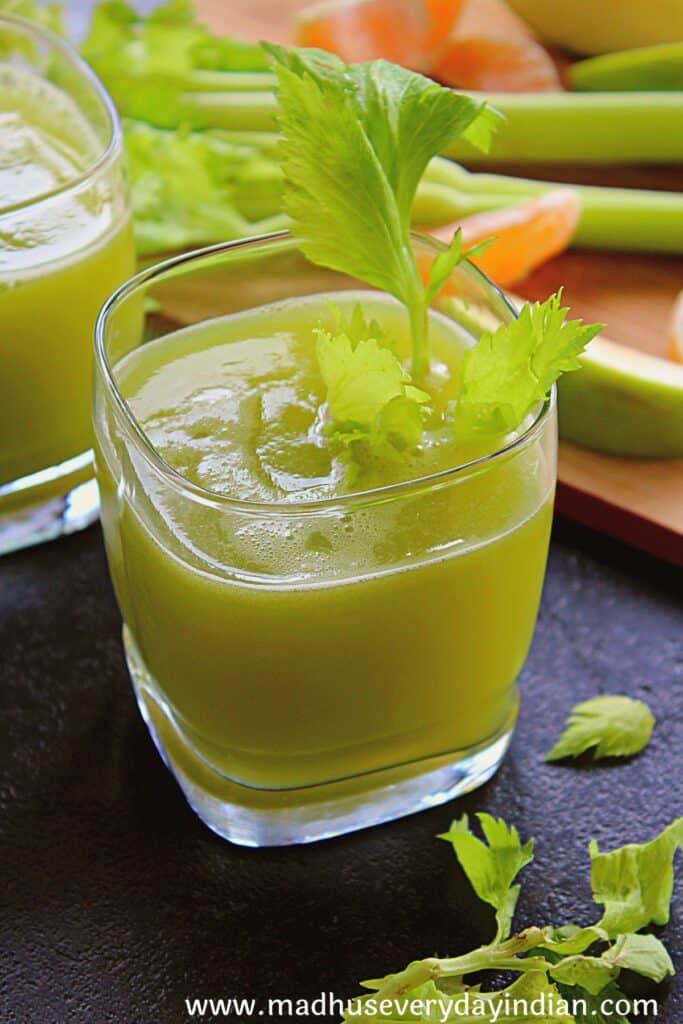 celery juice served ina  glass cup with celery leaves
