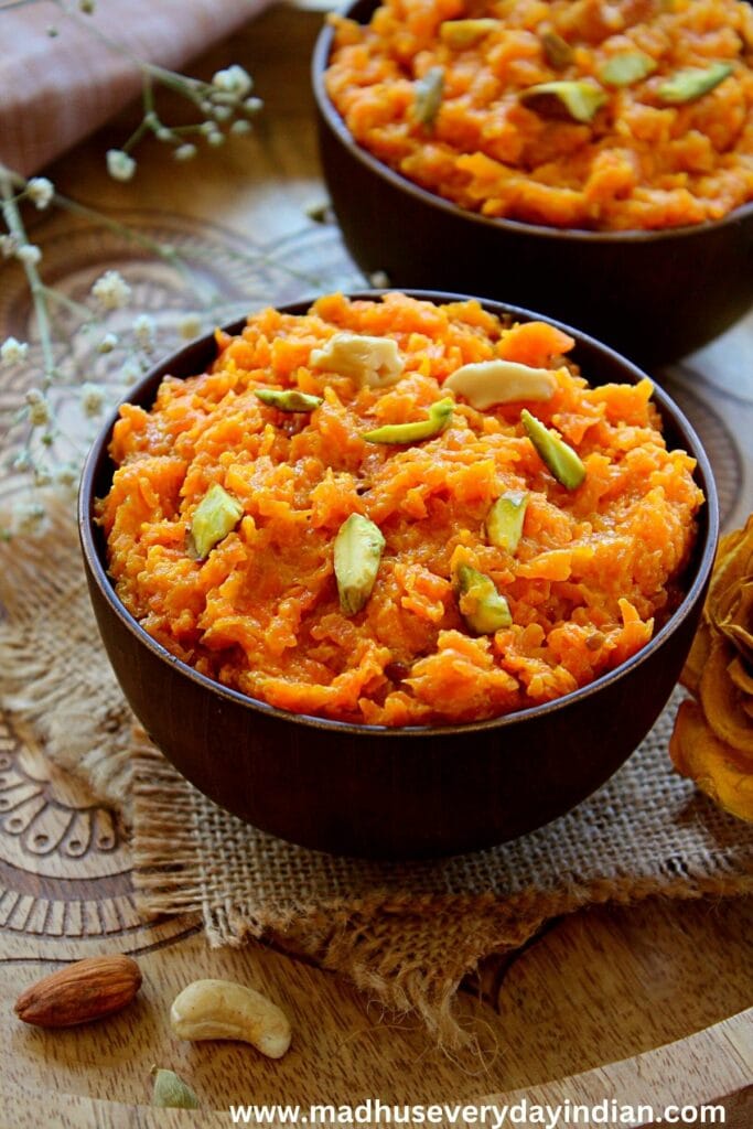 gajar halwa served in a brown bowl topped with pistachio