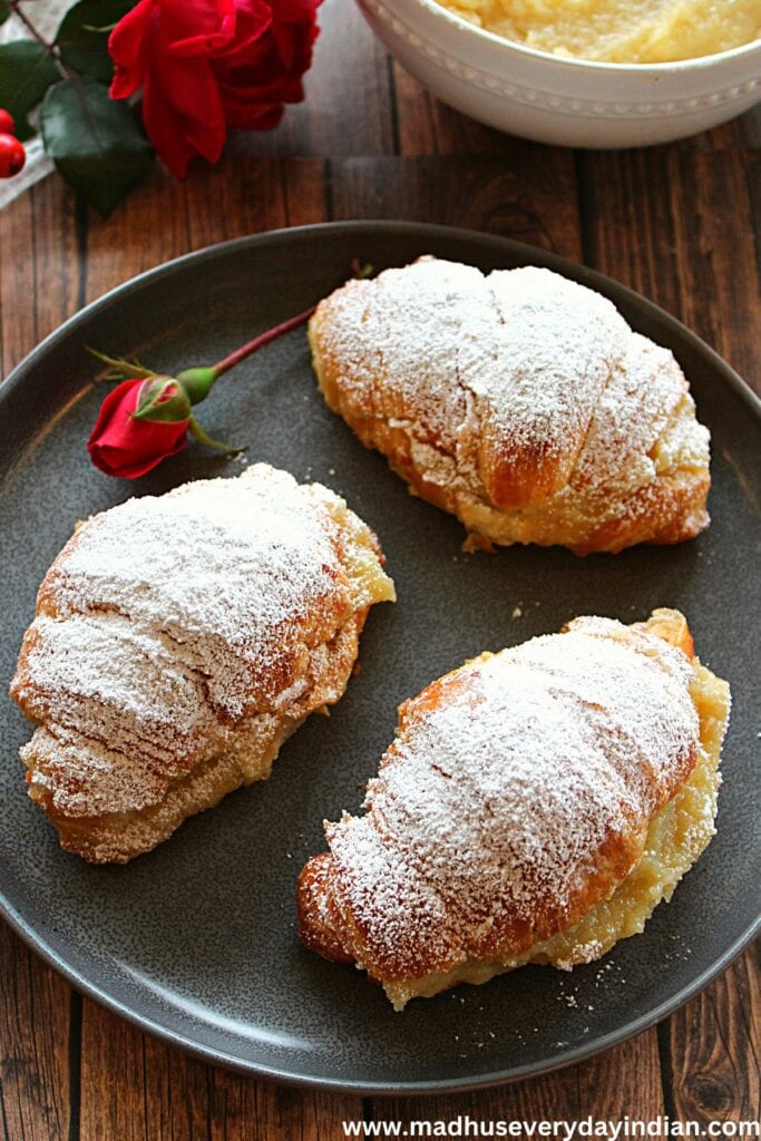 3 badam halwa croissants served in a plate with a rose